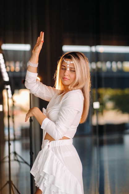 Beautiful smiling girl in a white dress dancing in the gym