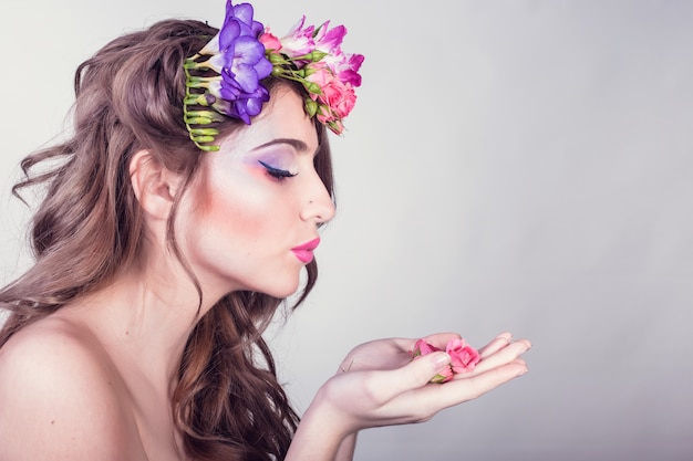 Bella ragazza sorridente con fiori tra i capelli