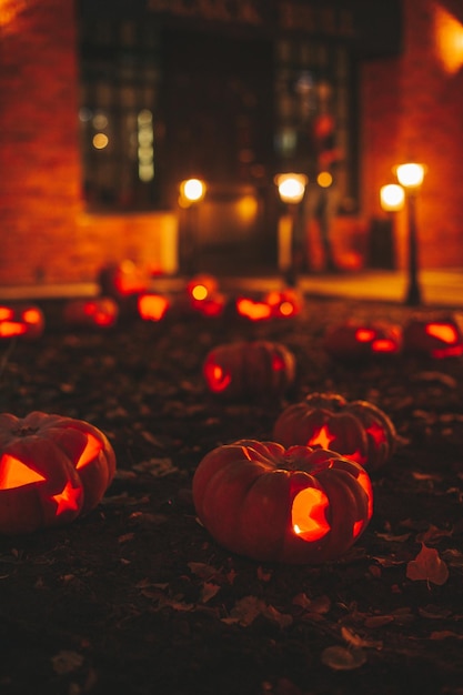 Beautiful smiling glow orange funny face carved pumpkins for Halloween holiday at night outdoor