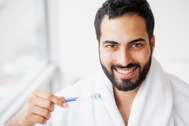 Beautiful Smiling Man Brushing Healthy White Teeth With Brush.