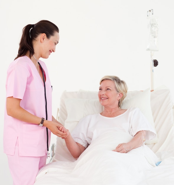 Beautiful smiling nurse helping a senior patient 