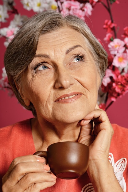 beautiful smiling senior woman drinking tea at home