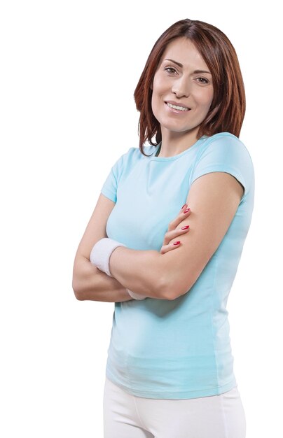 Una bella donna sportiva sorridente con le braccia incrociate guardando la fotocamera isolata