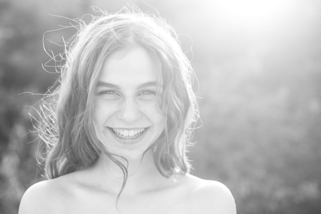 Beautiful smiling teenage girl in blue blouse against green of summer park beauty joyful teen girl o