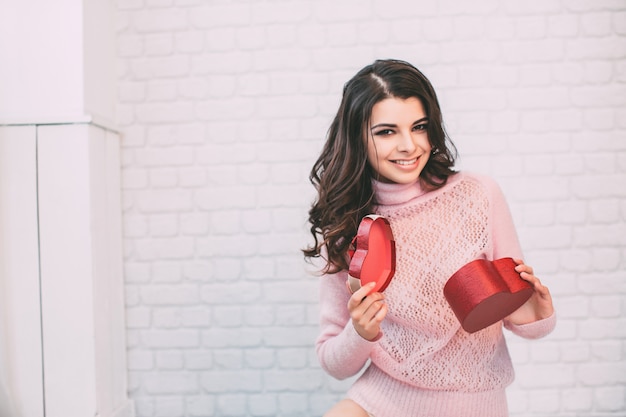 Photo beautiful smiling woman opens a gift.