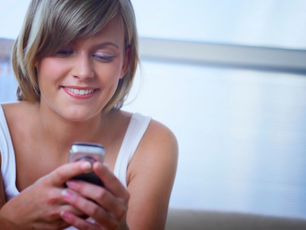 Photo beautiful smiling woman using phone at home