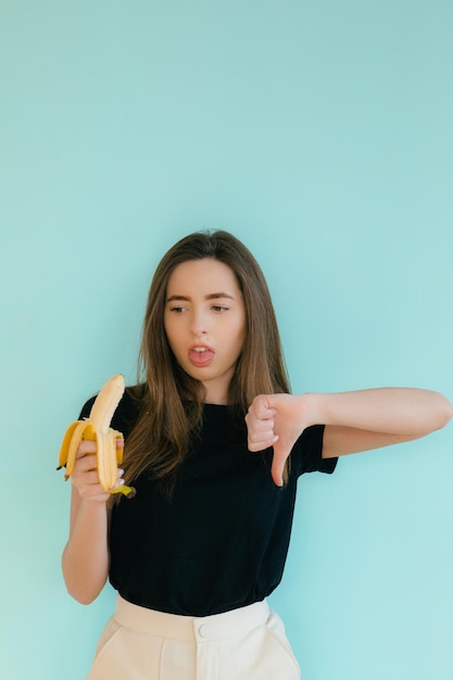 Beautiful smiling woman with banana near face