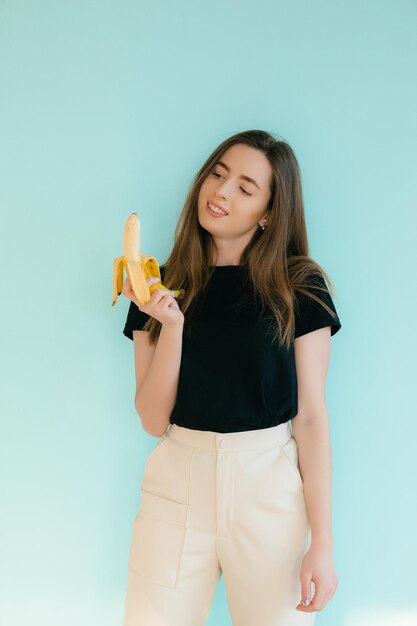 beautiful smiling woman with banana near face