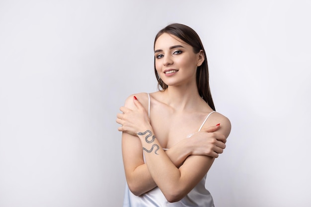 Bella donna sorridente con trucco naturale della pelle pulita e denti bianchi su sfondo grigio