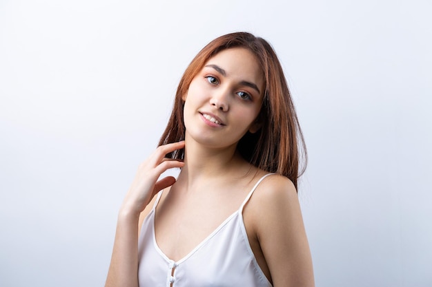 Beautiful smiling woman with clean skin natural makeup and white teeth on a gray background