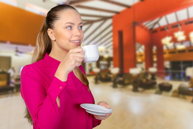 一杯のコーヒーで美しく、笑顔の女性