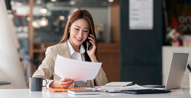 Photo beautiful smiling young entrepreneur businesswoman using mobile phone and working at office