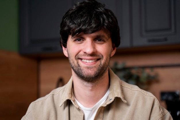 Photo beautiful smiling young man portrait of a happy laidback guy in the kitchen