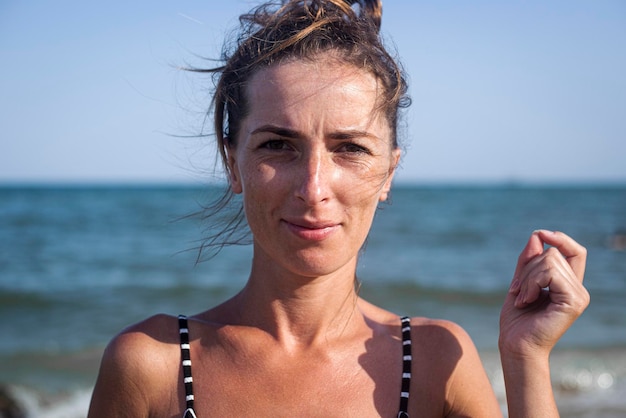 Foto bella giovane donna sorridente sulla spiaggia. concetto di viaggio.