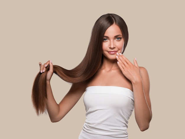 Beautiful smooth hair long brunette hairstyle woman healthy skin. Color background. Brown