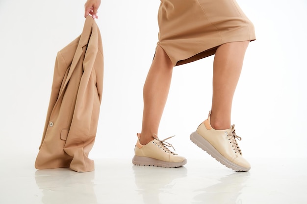 Beautiful sneakers on woman legs in the studio on white background