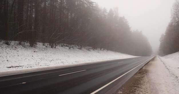 beautiful snowcovered road during fog in winter