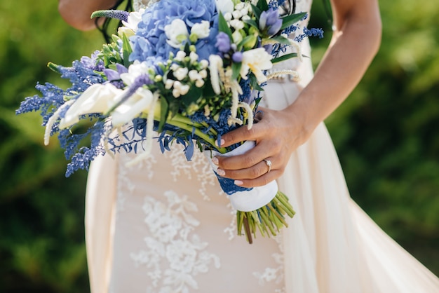 Il primo piano bello e sofisticato del mazzo di nozze tiene la sposa in sue mani. bouquet da sposa