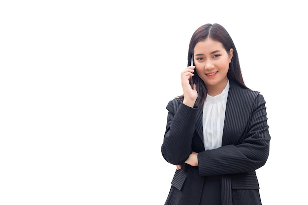 Una bellissima donna tailandese del sud-est asiatico che indossa un abito formale sorride e parla al cellulare. isolare su sfondo bianco, concetto di donna d'affari.