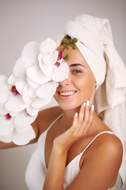 Foto bella ragazza della stazione termale isolata su un bianco. donna felice dopo il bagno con una pelle perfetta pulita