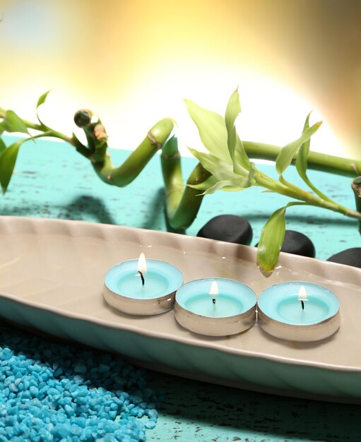 Beautiful spa setting with bamboo on wooden table on bright background