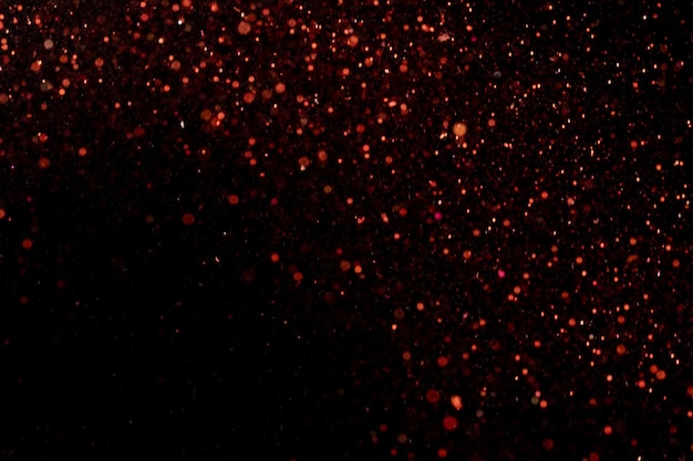 Photo beautiful, sparkling red glitter pouring down from above on a dark background