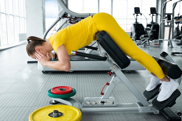 Beautiful sport woman doing press fitness exercise at gym