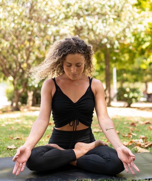 Beautiful sporty woman doing yoga exercise outdoors. Full boat pose.