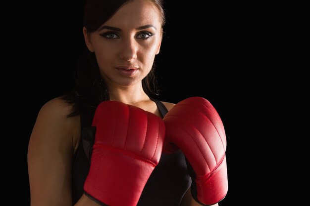 Красивая спортивная женщина в боксерских перчатках, глядя на камеру