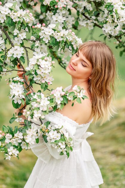 사진 꽃이 피는 나무에서 아름다운 봄 소녀.