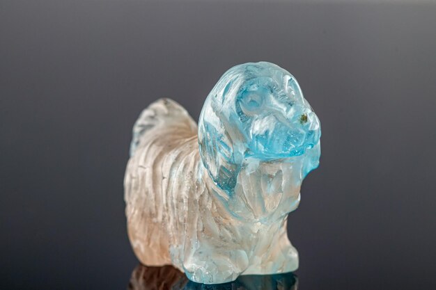 Beautiful statuette of a dog from the mineral topaz on a gray background