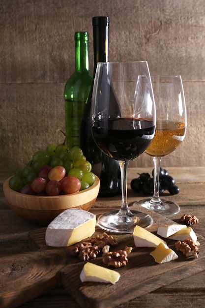 Beautiful still life with wine cheese and ripe grape on wooden background