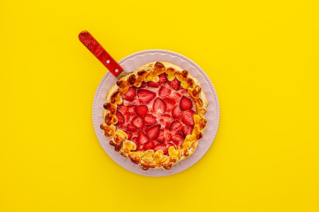 Beautiful strawberry gift pie on a plate with a spatula