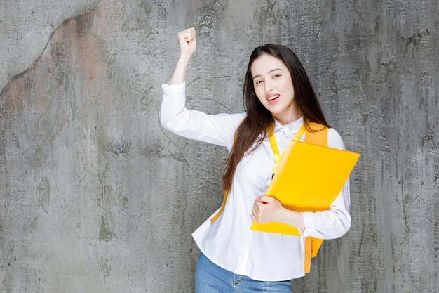 Beautiful student in white shirt holding book. High quality photo