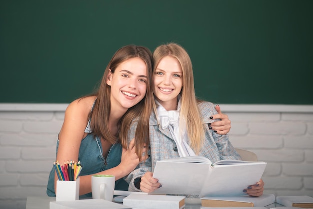 写真 学校の大学の教室で抱き締めて抱きしめる美しい学生の女の子