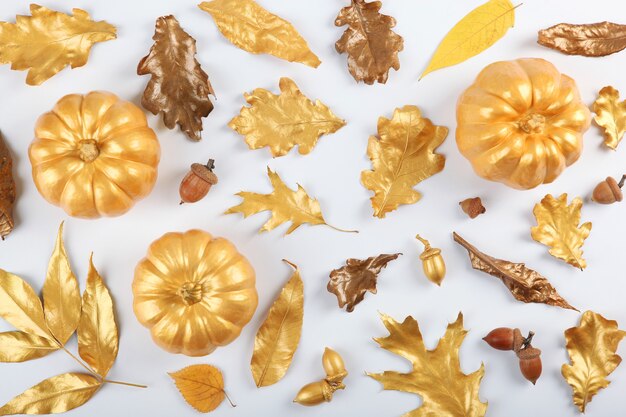 Beautiful stylish autumn background with golden leaves and pumpkins top view