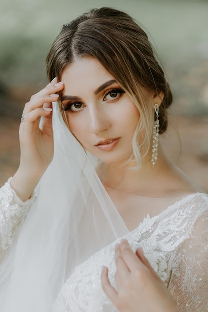 Beautiful stylish bride posing near old castle wall