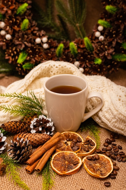 Beautiful stylish christmas composition with a cup of tea cinnamon and pine cones