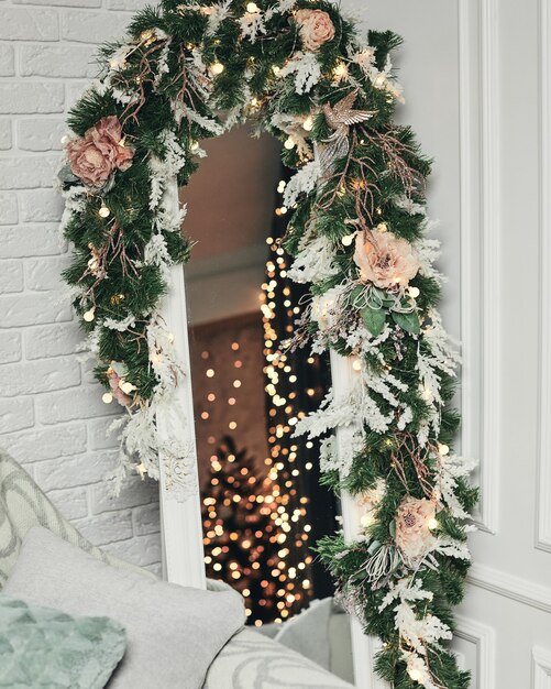 꽃과 가문비 나무 가지로 장식 된 아름다운 세련된 크리스마스 거울