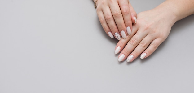 Beautiful stylish female manicure on a gray background.