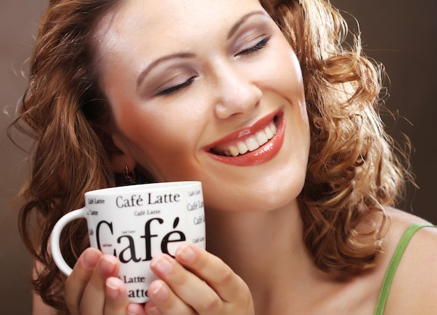 Foto bella ragazza alla moda che beve caffè