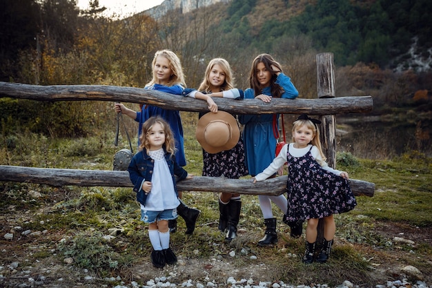 Belle amiche alla moda vicino a un lago di montagna nella foresta, stile denim. l'idea e il concetto di un'infanzia felice, sorellanza e unità con la natura