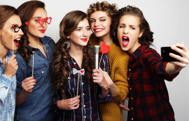 Photo beautiful stylish hipster girls singing karaoke