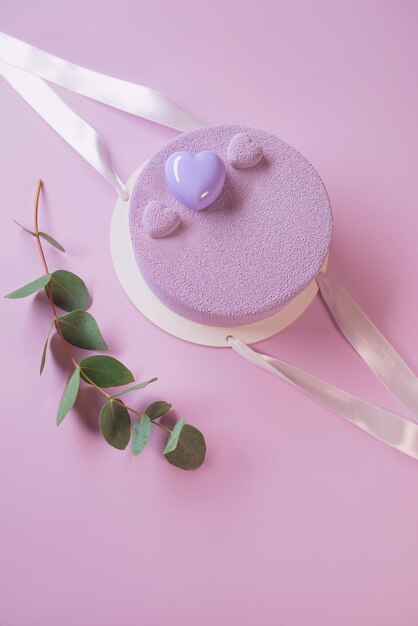 beautiful stylish modern violet purple homemade cake on violet background with eucalyptus twig