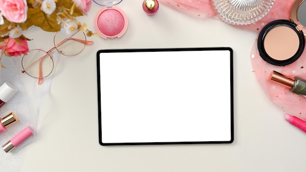 タブレットの白い画面のモックアップと美しいスタイリッシュなピンクの美容ブロガーワークスペースまたはオフィスデスク
