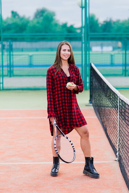 Beautiful stylish sexy woman in a black trendy sportswear on tennis court.