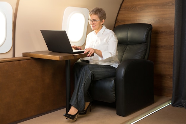 Beautiful stylish woman in the cabin of a private plane