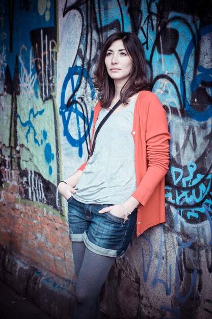 Beautiful stylish woman and graffiti wall