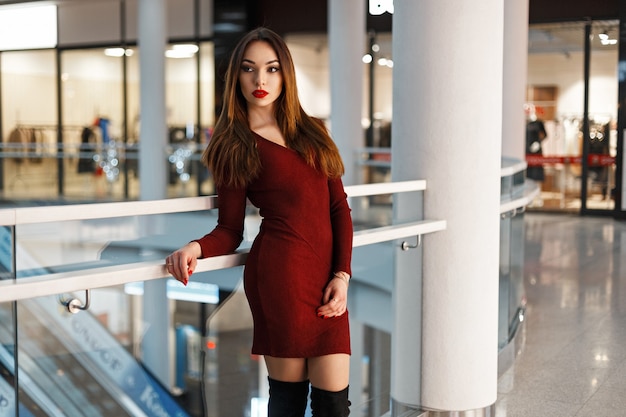 Beautiful stylish woman in a red dress shopping  at the store