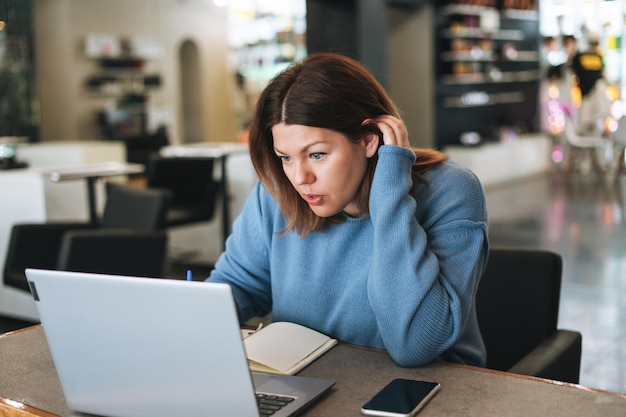 Beautiful stylish young woman plus size body positive using laptop at the beauty salon office s